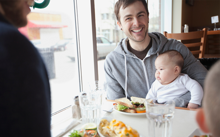 Adults and a baby at a lunch table.
