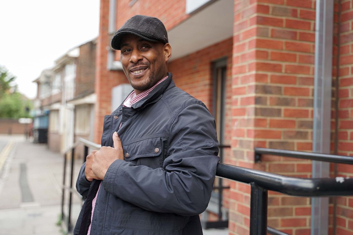 Chris Telesford in front of about brick exterior to a building.