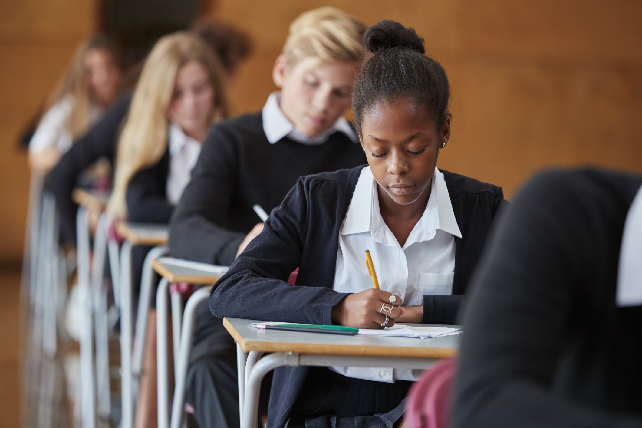 Students sitting exams in a school hall. 